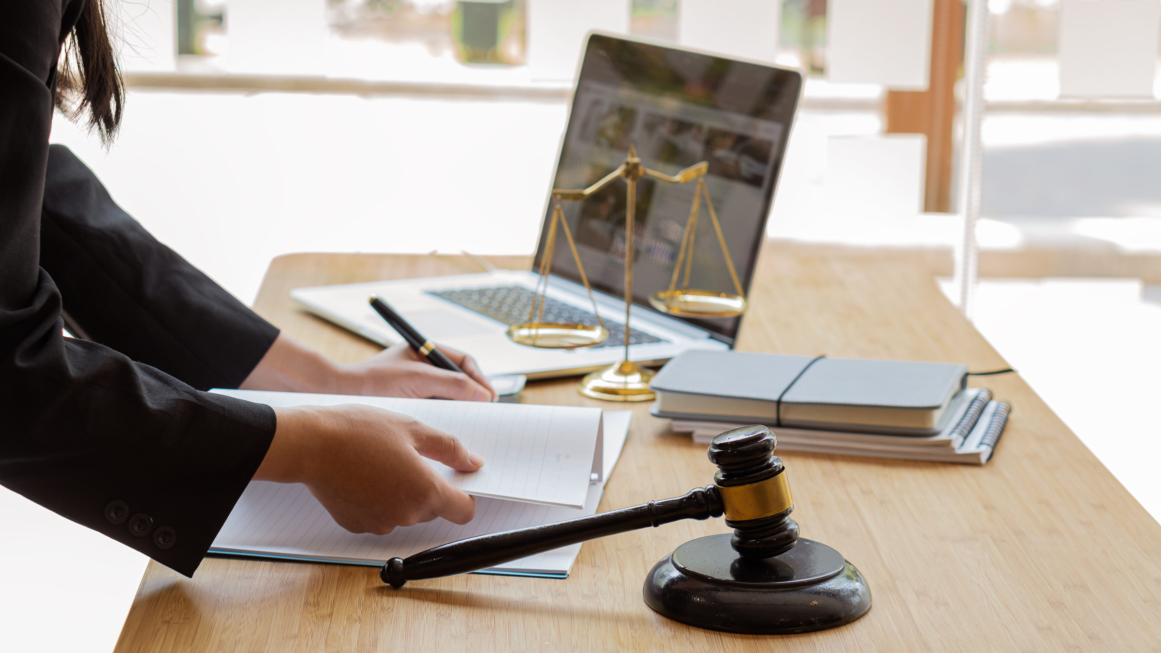 A lawyer with a brass scale on a desk in an office Law legal services, justice advice and legal concept images